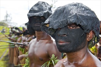 Members of a tribe with black painted faces at the traditional sing-sing gathering
