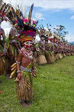 Members of a tribe in colourfully decorated costumes with face paint at the traditional sing-sing gathering