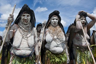 Women in colourfully decorated costumes with face and body paint at the traditional sing-sing gathering