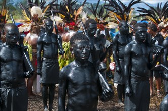 Members of a tribe covered in black paint at the traditional sing-sing gathering