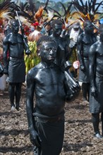 Members of a tribe covered in black paint at the traditional sing-sing gathering