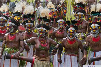 Members of a tribe in colourfully decorated costumes with face paint at the traditional sing-sing gathering