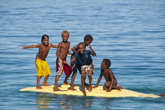 Children playing with a surf board