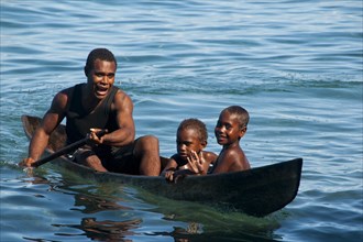 A man and two children in a canoe