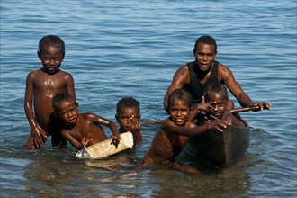 A man and children with a canoe