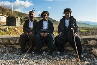 Kurdish men sitting on a wall