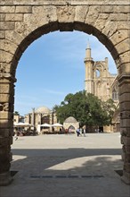 View through an archway towards a minaret and tower