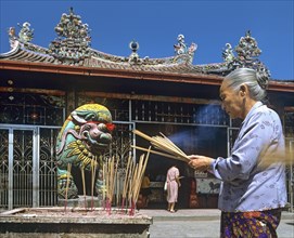 Elderly woman with incense