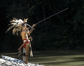 Head hunter of the ethnic group of the Iban people with a blowpipe