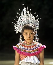 Girl of the ethnic group of the Iban people wearing traditional dress with a headdress
