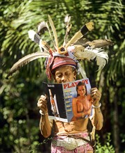 Head hinters of the ethnic group of the Iban people reading a Playboy magazine