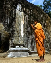 Buddhist monk praying in front of the Deepangkara Buddha statue