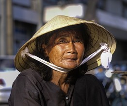 Elderly Vietnamese woman with a conical hat or Non La