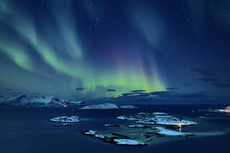 Fjord with islands in winter and the northern lights