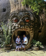 Two girls in the mouth of a spirit at the entrance to Xieng Khuan Buddha Park