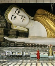 Buddhist monk standing in front of the Shwethalyaung-Buddha