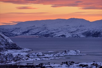 Fjord with islands in winter at sunset