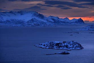Fjord with mountains in winter at sunset