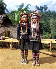 Two Akha girls in a mountain village in traditional costume and headdress