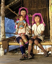 Long-necked woman with a girl and a baby of the Padaung mountain tribe
