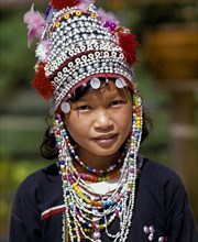Akha girl wearing a colourful headdress and the traditional costume of the mountain people