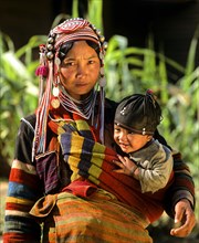 Young Akha woman carrying a child