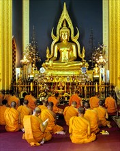 Monks at prayer in front of the Phra Phutthachinnarat