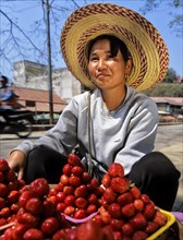 Young woman with fresh strawberries at a market