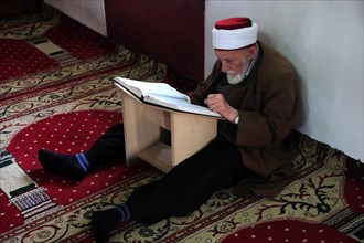 Muslim man studying the Quran in the Et'hem Bey Mosque
