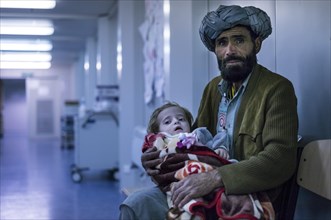 Afghan man with a child awaiting treatment in the field hospital of PRT Feyzabad operated by the German Army