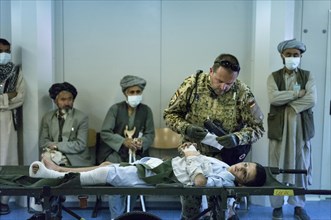 Bundeswehr doctor treating an Afghan boy in PRT Feyzabad