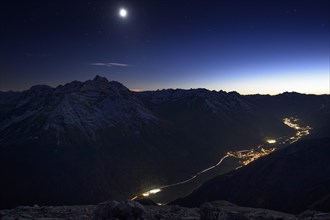 Mountain panorama with the full moon and a view over the valley