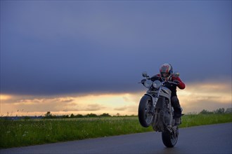 Motorcyclist in front of a dramatic cloudy sky