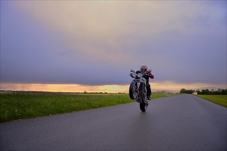 Motorcyclist in front of a dramatic cloudy sky