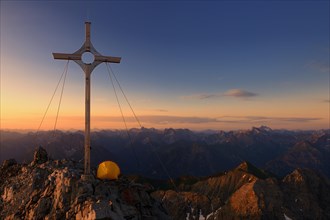 Summit cross with a tent on Grosser Krottenkopf Mountain at sunrise