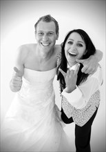 Smiling bride wearing a suit and a groom wearing a wedding dress