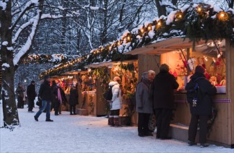 People strolling through the Christmas market in the English Garden