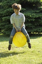 Boy jumping with a hop ball