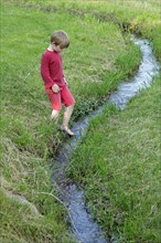 Boy playing on a creek