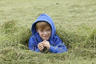 Young boy lying in the hay