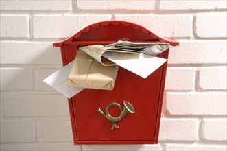 Red mailbox stuffed with letters and parcels