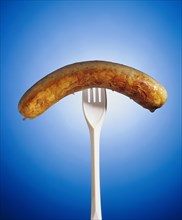 Grilled sausage on a plastic fork