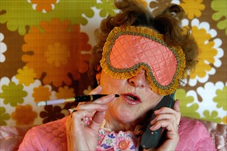 Old lady with sleep blindfold and cigarette with a holder