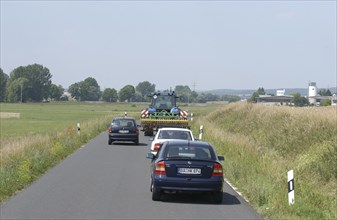 Cars overtaking a tractor on a country road