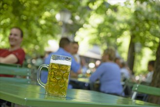 Full beer mug on a table in a beer garden