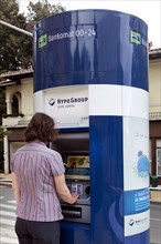 Woman extracting money from an ATM of the bank of Hypo Group Alpe Adria in Opatija