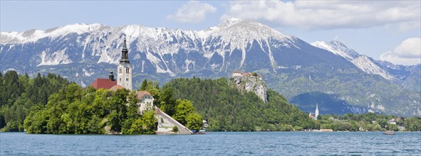 Blejski Otok Island with St. Mary's Church in Lake Bled and The Karawanks mountain range in Bled