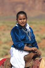 Navajo Indian woman riding a horse