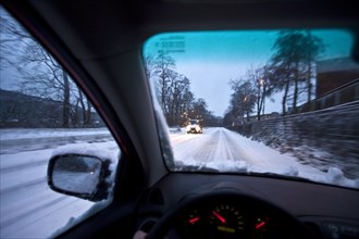 Driving a car in snow at dusk