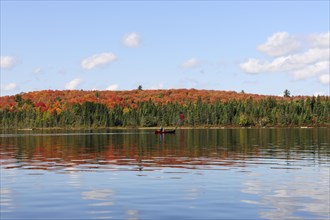Canoe Lake with canoeists and a forest in autumn colours
